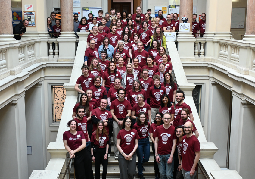 Group photo of the volunteers in red University of Vienna T-shirts on the main staircase of the University Observatory